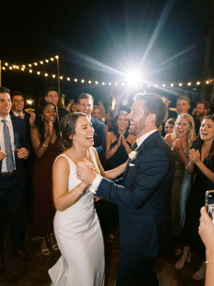 The couple dancing, lit by a phone flash