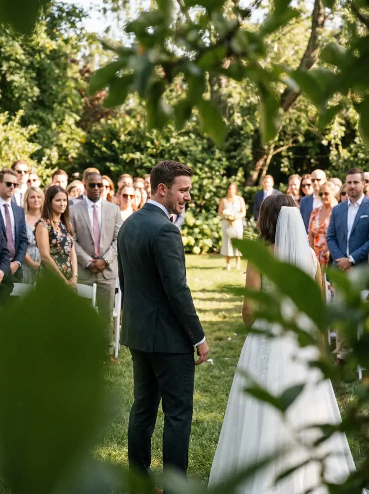 The groom turning to see the bride, seen through leaves