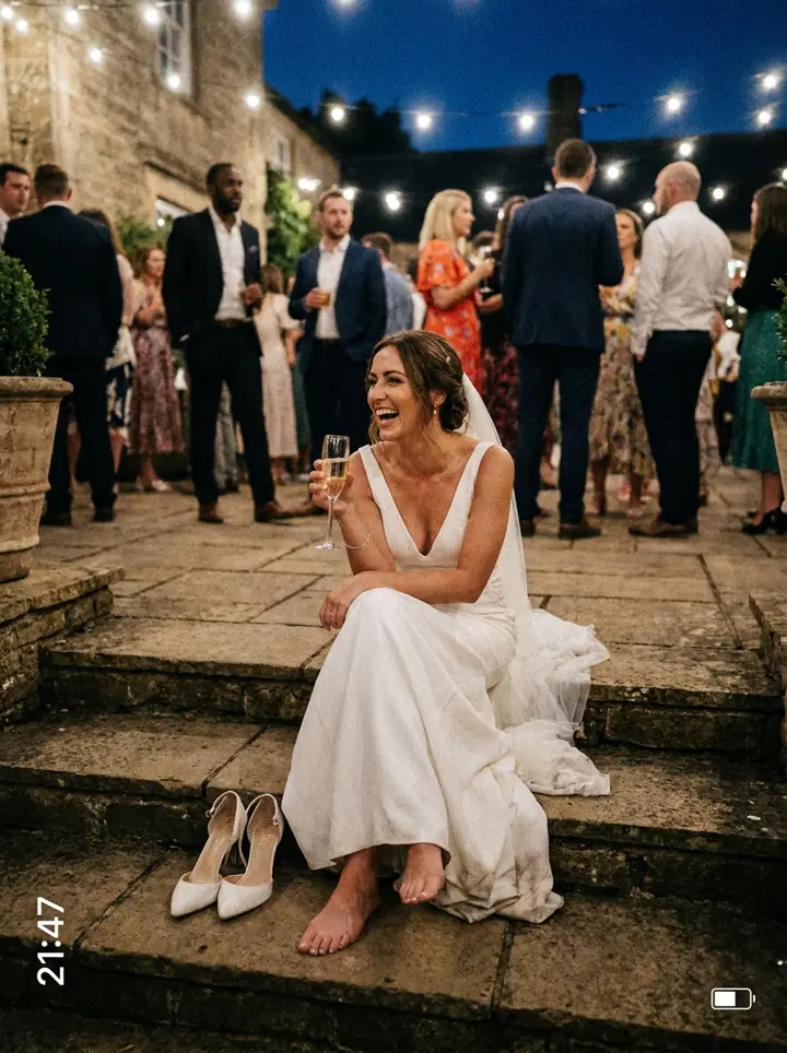 The bride laughing on the steps with her shoes off
