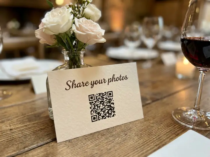 A 'Share your photos' QR card on a reception table